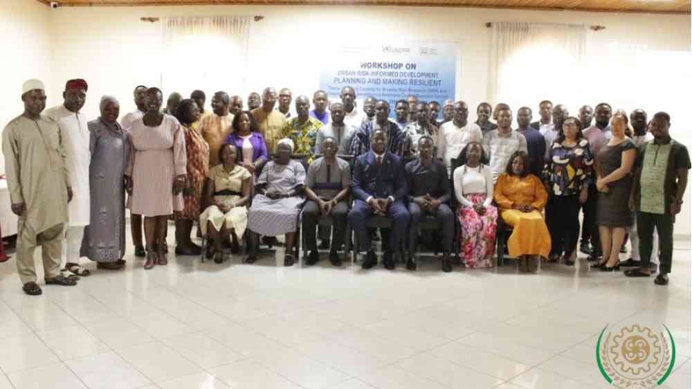 Group photo of government and civil society stakeholders, and development partners at the workshop. They are arranged in two rows, and the photo has been taken indoors
